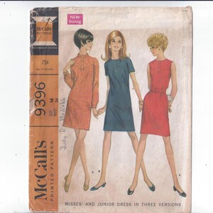 May include: Vintage McCall's printed pattern for misses' and junior dresses. The cover shows illustrations of three dress styles in orange, blue, and red. The pattern number is 9396, with a size 14 and bust 91 cm. The text "NEW Sizing" is visible.