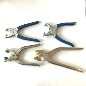 May include: Four metal hand pliers for attaching fasteners. Two pliers have blue rubberized handles and silver heads. Two pliers have solid silver metal handles, with one featuring green plastic inserts and the other featuring yellow plastic inserts.