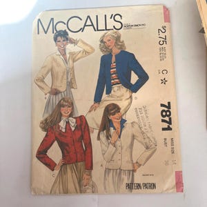 May include: A McCall's sewing pattern envelope 7871 for miss size 14, bust 36. The front features illustrations of four different jacket styles in beige, blue, and red, worn over skirts. Text includes the brand name, pattern number, and price.