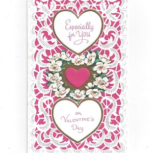 Könnte beinhalten: Eine Vintage-Valentinstagskarte mit pinkfarbenem Hintergrund und weißem, spitzenähnlichem Rand. Die Karte zeigt zwei herzförmige Rahmen mit den Aufschriften "Especially for You" und "on Valentine's Day". Eine Blumengesteck und ein rosa Herz befinden sich in der Mitte.