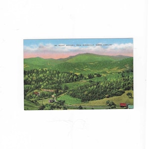 Könnte beinhalten: Vintage Postkarte mit einer malerischen Ansicht des Mount Mitchell von Burnsville, North Carolina. Die Landschaft zeigt grüne Hügel, dichte Wälder und einen blauen Himmel. Der Text "118 - MOUNT MITCHELL FROM BURNSVILLE, NORTH CAROLINA" ist enthalten.