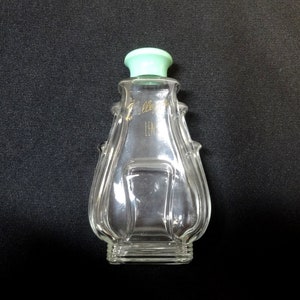 May include: A clear glass bottle with a green plastic lid. The bottle has a unique, textured design and features the text "Jolleys Len"