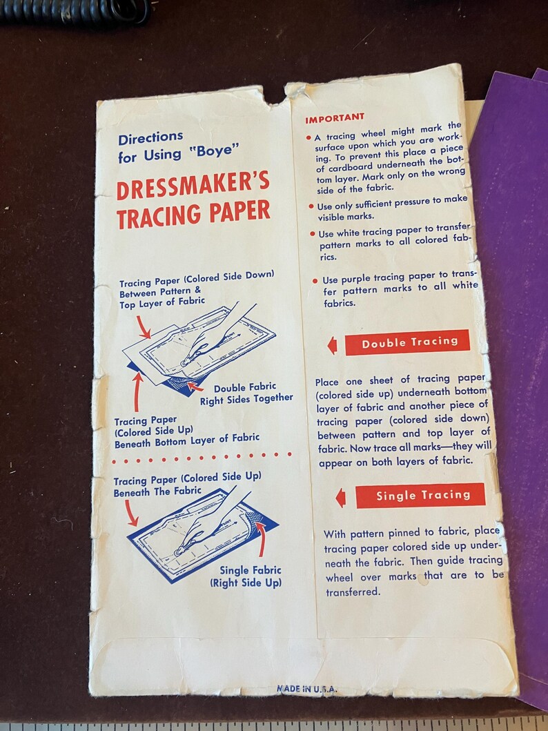 May include: A rectangular instruction sheet for Boye Dressmaker's Tracing Paper with white background, red and blue text, and diagrams illustrating double and single fabric tracing techniques. The paper shows wear along the edges and folds.