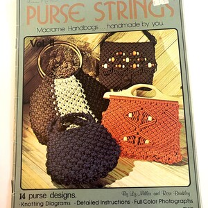 May include: A craft instruction book titled Purse Strings Vol II featuring macrame handbags. The cover displays four handmade bags in brown, dark blue, and orange with wooden beads and handles, along with text detailing 14 purse designs.
