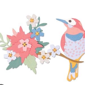 May include: A colorful papercraft design featuring a bird perched on a branch next to a cluster of flowers. The bird has pink, blue, and white details. The flowers are pink, white, and blue with yellow centers, and green leaves.