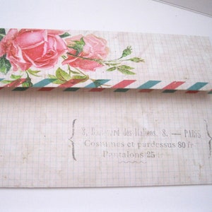 May include: An open, vintage-style envelope with a floral rose design and a red, white, and teal border. The envelope has a grid pattern and text that reads "8, Boulevard des Italiens, 8. - PARIS".