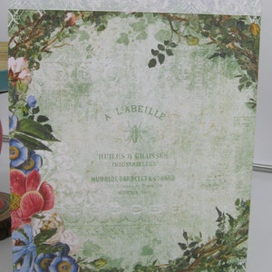 May include: A vintage-style green and white floral design with a logo for a company called "A L'Abeille" that sells oils and greases. The logo features a bee and the text "Huiles & Graisses Industrielles Humflot, Barbelet & Conard 110 Avenue de Paris, 110."