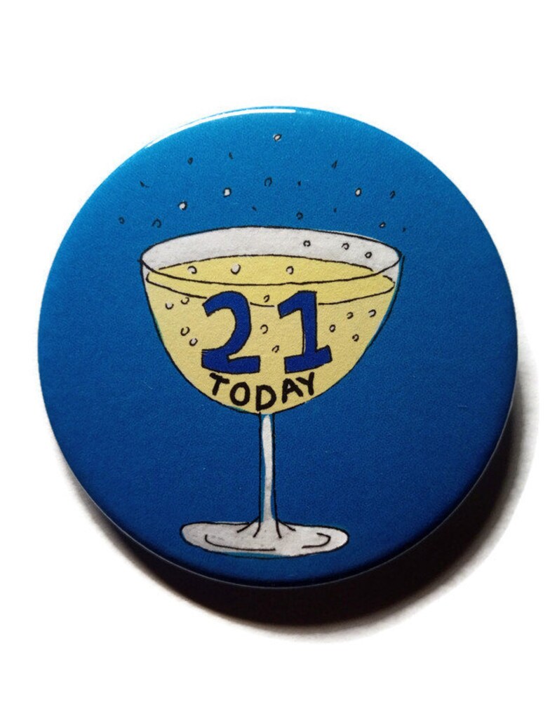 May include: A blue round button with a yellow champagne glass with the number 21 in blue and the word "TODAY" in black.