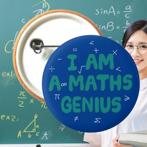 May include: A blue button with the text "I AM A MATHS GENIUS" in green letters surrounded by mathematical symbols. The button is pinned to a green chalkboard with maths equations written on it.