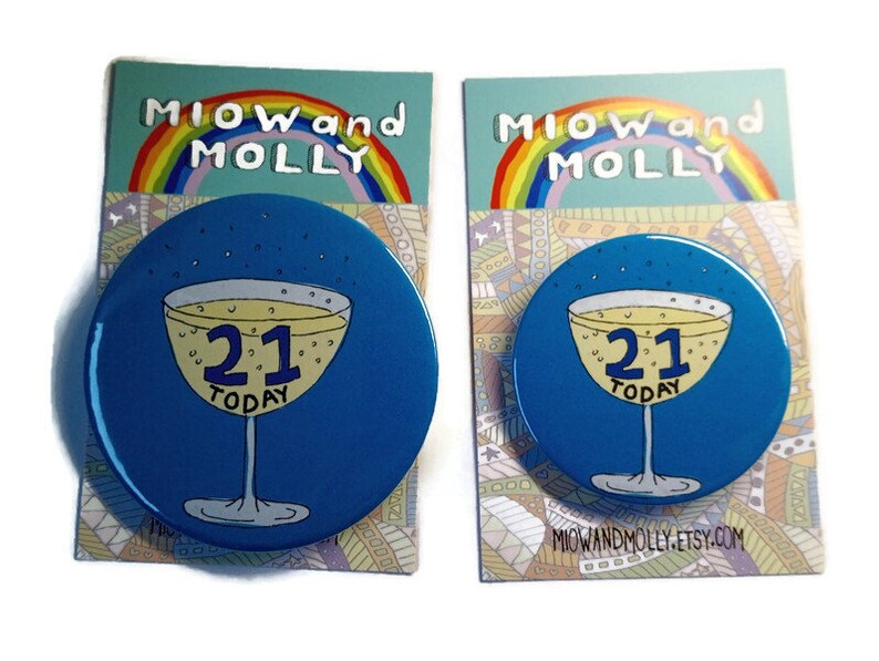 May include: Two blue round 21st birthday buttons with a champagne glass and the text "21 Today" on each. The buttons are on a white background with a rainbow and the text "MIOW and MOLLY" on each.