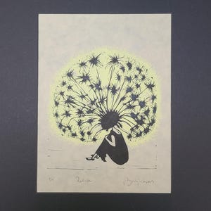 以下が含まれることがあります： 明るい色の紙に印刷された、座っている人物の黒いシルエット。頭部は大きく詳細なタンポポの綿毛に置き換えられています。タンポポは淡い黄色の光で強調されています。下部には手書きのテキストが記されています。