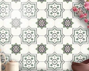 May include: A wall covered in square tiles featuring a repeating pattern of sage green and dark gray geometric star shapes with central floral motifs on a white background. The text BleUcoin is visible on a wooden cutting board in the foreground.