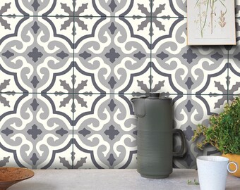 May include: A wall covered in square tiles featuring a repeating geometric pattern in shades of white, light gray, and dark charcoal gray. The design consists of interlocking curved lines and star-like shapes. The text BleUcoin is in the top left corner.