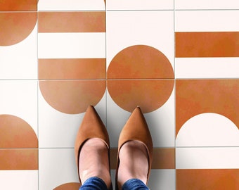 May include: A pair of brown shoes with pointed toes stand on a floor with a geometric pattern of white and orange tiles.
