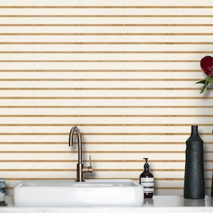 Puede incluir: Un tocador de baño blanco con un lavabo de porcelana blanca y un grifo de níquel cepillado. El tocador tiene dos cajones y está hecho de madera. El salpicadero está hecho de azulejos blancos con líneas marrones.