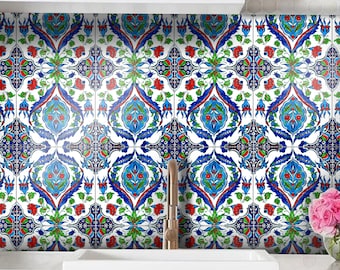May include: A white farmhouse sink sits below a backsplash of square ceramic tiles featuring a repeating Iznik-style pattern in vibrant shades of blue, red, and green. A metallic faucet is centered in front of the tiled wall above the sink.