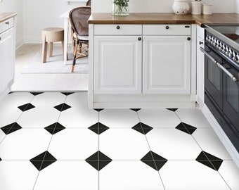 May include: A white kitchen with black and white diamond patterned tile flooring. The kitchen features white cabinets, a wooden countertop, and a black oven. There is a dining area with a wooden table and chairs in the background.