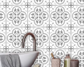 May include: A wall covered in square tiles featuring a repeating gray and white floral quatrefoil pattern. The design includes symmetrical leaf motifs centered within each tile, creating a continuous geometric grid across the entire surface.