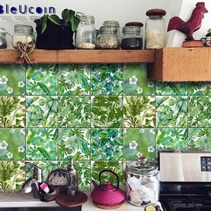 May include: Green and white tropical leaf patterned tile stickers for a kitchen backsplash. The stickers are arranged in a grid pattern and cover a section of the kitchen wall.