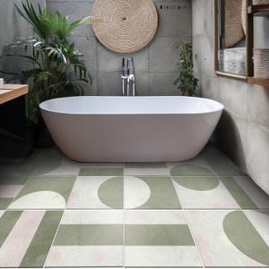 Może przedstawiać: Nowoczesna łazienka z białą owalną wanną, wzorzystą podłogą z płytek w kolorze zielonym, białym i różowym oraz tkaną dekoracją ścienną. Ściany są szare, z roślinami i lustrem. Projekt jest minimalistyczny i stylowy.