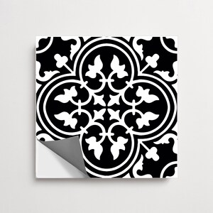 May include: A square tile sticker featuring a high-contrast black and white pattern. The design consists of a central quatrefoil shape surrounded by symmetrical, stylized floral and leaf motifs. One corner of the sticker is peeled back to reveal a gray backing.