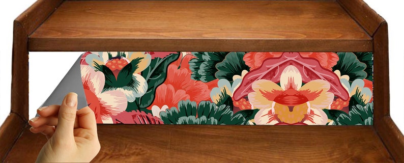 K&ouml;nnte beinhalten: Ein rechteckiger Klebeaufkleber mit einem lebendigen Blumenmuster aus gro&szlig;en, stilisierten rosa, orangefarbenen und dunkelgr&uuml;nen Bl&uuml;ten und Bl&auml;ttern. Der Aufkleber hat eine abziehbare R&uuml;ckseite mit grauer Klebefl&auml;che auf einer Holzoberfl&auml;che.
