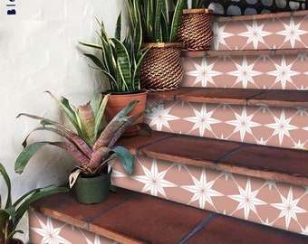 Puede incluir: Escalera con escalones de terracota y contrahuellas decoradas con baldosas con estampado de estrella blanca sobre un fondo rosa empolvado. Plantas en macetas, incluyendo sansevierias y bromelias, añaden vegetación.