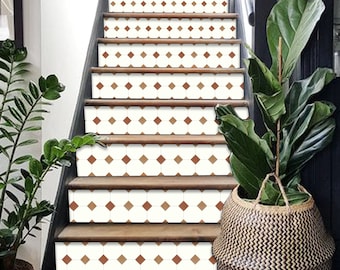 Puede incluir: Un conjunto de escaleras de madera marrón con pegatinas de azulejos de diamante blanco y marrón. Las escaleras están en una casa con una planta en una cesta de mimbre.
