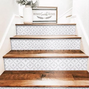 Könnte beinhalten: Weiße und graue Treppenstufen mit Muster auf einer Holztreppe. Ein Holzschild mit dem Text "Home Sweet Home" befindet sich über den Stufen.