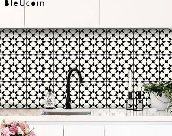 May include: Black and white geometric tile backsplash with a starburst pattern. The tiles are installed in a kitchen behind a white countertop and sink.