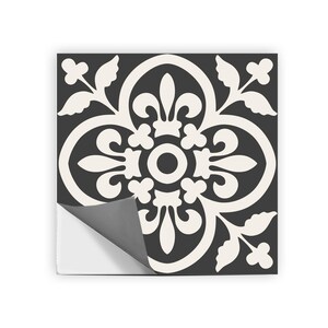 A single black and white patterned tile sticker with one corner peeled back to reveal a gray adhesive backing.