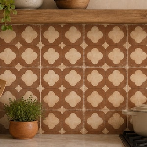 May include: A kitchen backsplash featuring square tiles with a repeating pattern of light beige four-leaf clover shapes on a dark brown background. The tiles are arranged in a grid, creating a consistent geometric design across the wall surface.