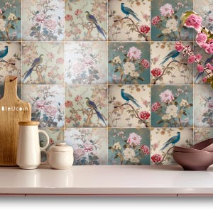 May include: A set of nine decorative ceramic tiles featuring a floral pattern with blue birds. The tiles are arranged in a 3x3 grid and have a vintage aesthetic.