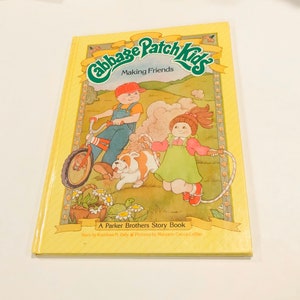 May include: A yellow book cover with the title "Cabbage Patch Kids Making Friends" and a picture of two children, a boy riding a bike and a girl jumping rope. The book is a Parker Brothers Story Book.