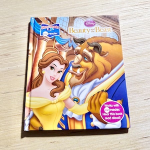 May include: A children's book titled "Beauty and the Beast" featuring Belle and the Beast. The cover has a colorful illustration of the characters. The book is part of the Story Reader series and includes a "me reader" feature.