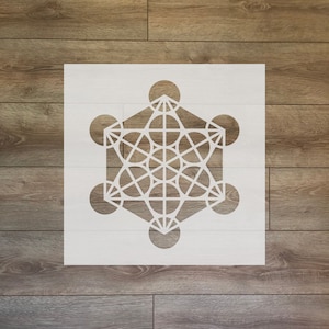 May include: White stencil of a geometric design with a hexagonal shape and overlapping circles. The design is similar to the Flower of Life pattern.