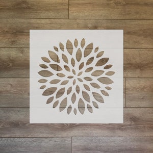 Op de afbeelding: Witte stencil met een bloemmotief. Het ontwerp is een cirkel van overlappende bloemblaadjes.