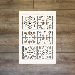 Könnte beinhalten: Eine weiße Schablonenfolie mit sechs verschiedenen Fliesenmustern. Die Muster sind alle filigran und zeigen florale Designs.