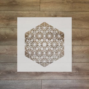 Puede incluir: Una plantilla blanca con un diseño geométrico de un hexágono con un patrón complejo de líneas y círculos en su interior.