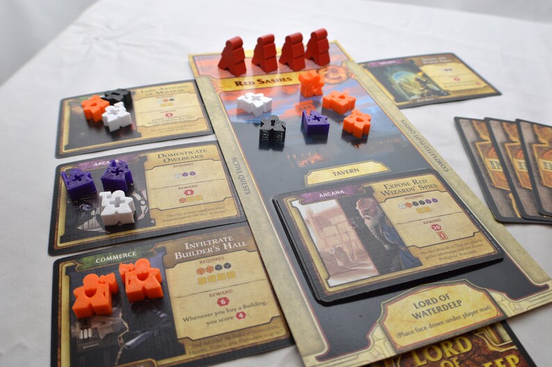 May include: A board game with a variety of colorful game pieces, cards, and a game board. The game board features a tavern, an arcana, and a red sashes area. The cards include "Domesticate Owlbears", "Infiltrate Builder's Hall", "Expose Red Wizard Spies", and "Lord of Waterdeep".