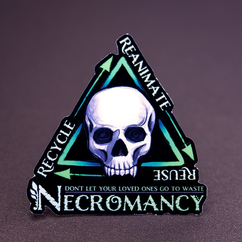 May include: A black and green sticker with a skull in the center and the words "REANIMATE", "REUSE", "RECYCLE" and "NECROMANCY" around it. The sticker is shaped like a triangle with arrows pointing in a circular motion.