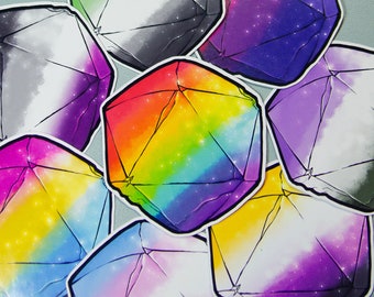 May include: A collection of colorful, geometric stickers. Each sticker features a faceted shape with a unique color gradient, including rainbow, purple, yellow, and green hues. The designs have a galaxy-like appearance, with subtle star-like details.