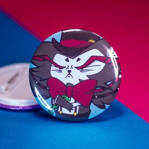 May include: A round button with a cartoon image of a black cat wearing a top hat, bow tie, and a serious expression. The cat is holding a cane in its right paw.