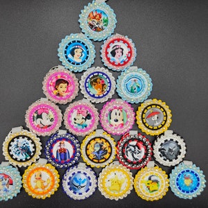 May include: A collection of 20 round, beaded, colorful ornaments featuring various Disney characters. Each ornament is approximately 2 inches in diameter and features a different character, including Mickey Mouse, Minnie Mouse, Snow White, and others.