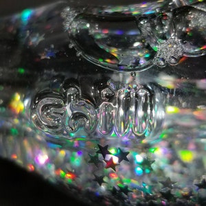 May include: A clear glass sphere filled with iridescent glitter and the word "chill" embossed on the surface.