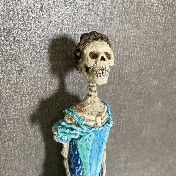 Skeleton lady sculpture made from Tabasco bottle and paper mache.