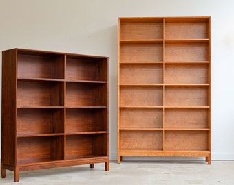 Könnte beinhalten: Zwei Bücherregale aus Holz. Das linke ist dunkelbraun mit acht Regalen, das rechte hellbraun mit zehn Regalen. Beide haben ein rechteckiges Design und sind leer.