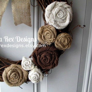 May include: A brown twig wreath decorated with burlap flowers in shades of brown, beige, and white. The wreath is accented with burlap bows and the text "Anita Rex Designs anitarexdesigns.etsy.com".