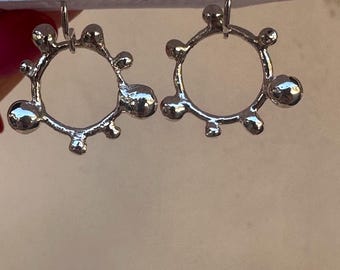 sculpted silver circle with solid silver balls adoring the outside of circle