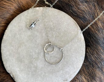 The 18" Lydia necklace is made of two sterling silver interlocking circles of contrasting size connected to a sliver chain